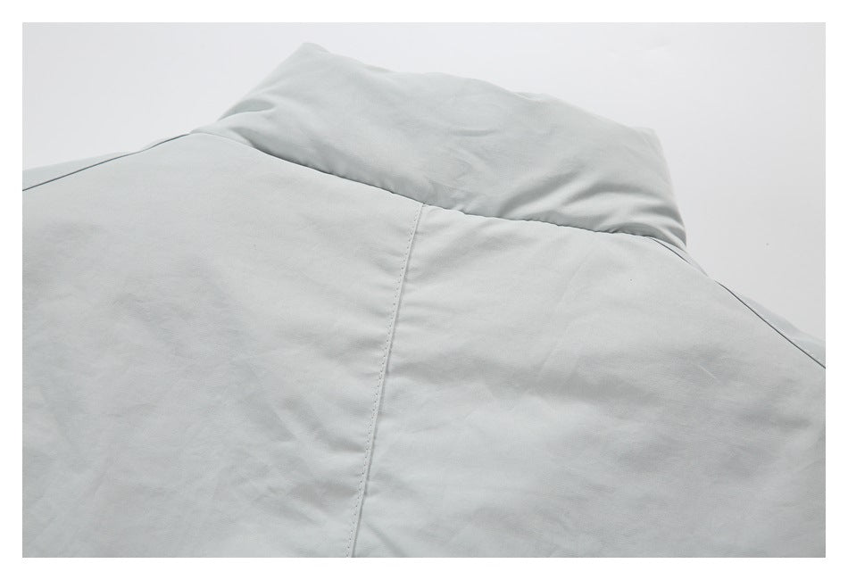 Close-up of the back neckline and hood seam on a light gray garment.