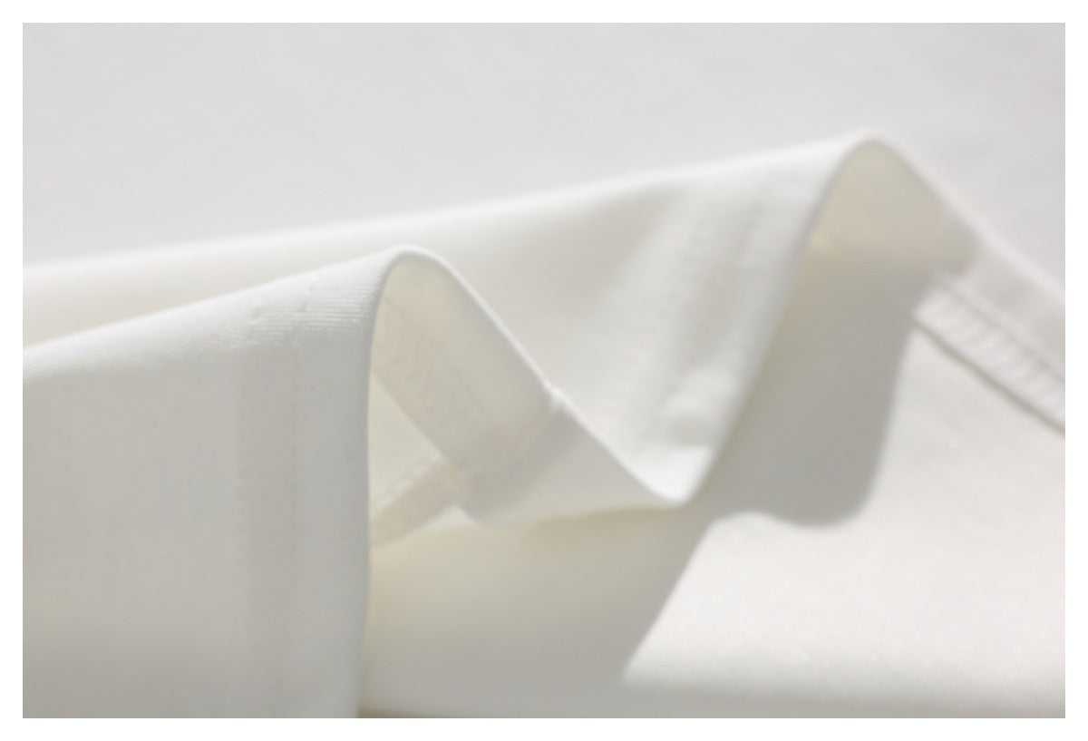 Close-up of folded white fabric showing its surface and edge.