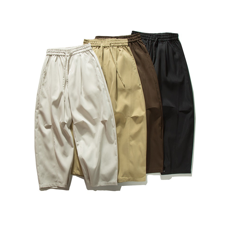 Four pairs of loose trousers with elastic waists, shown in cream, tan, brown, and black.