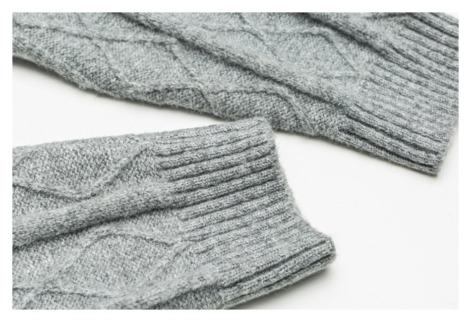Close-up of two ribbed cuffs on a gray cable-knit sweater.
