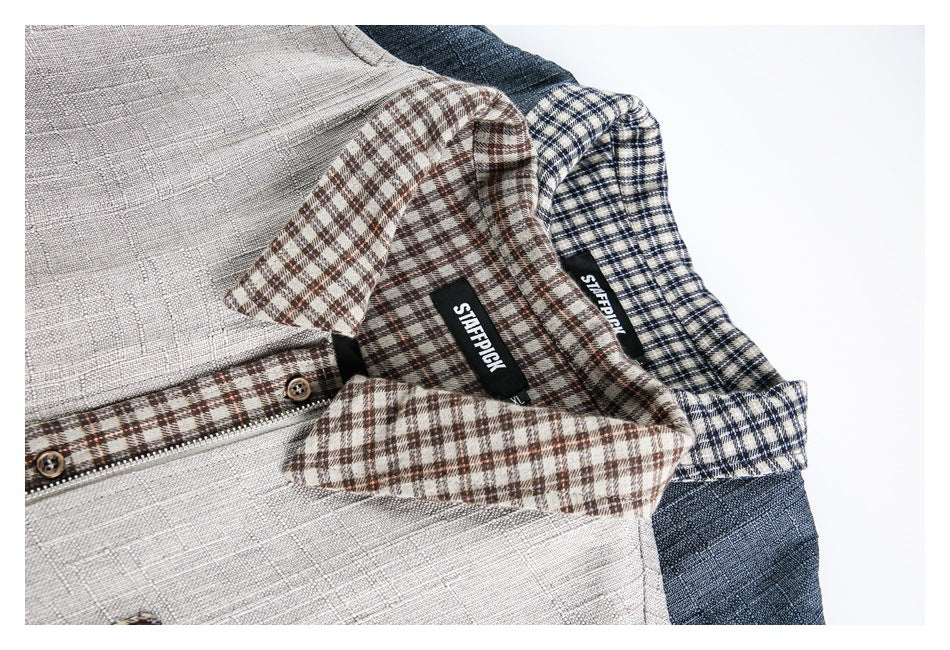 Close-up of overlapping gray and blue-gray jackets showing plaid collars, inner labels, and front zipper details.