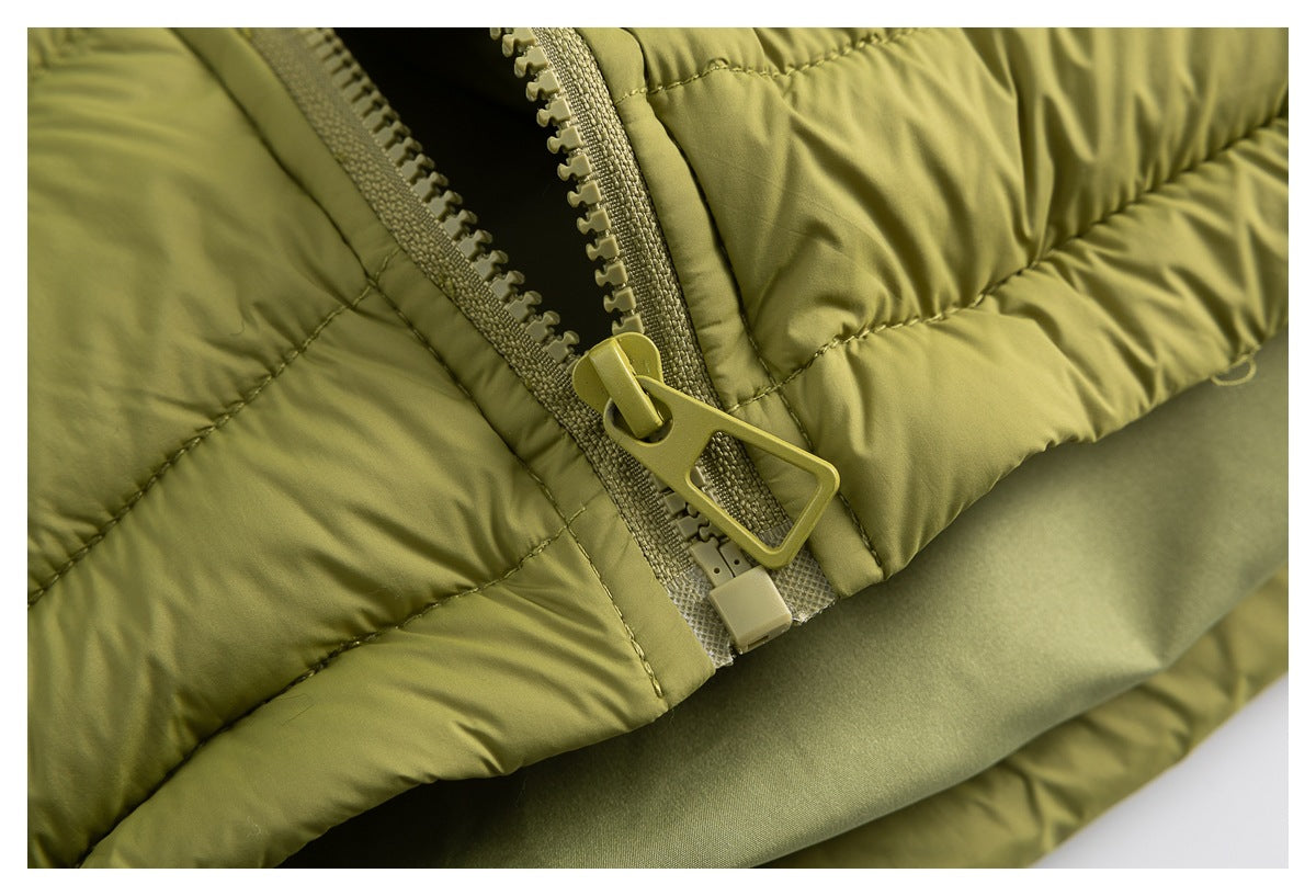 Close-up of the olive-green jacket's open chunky zipper and padded stitching.