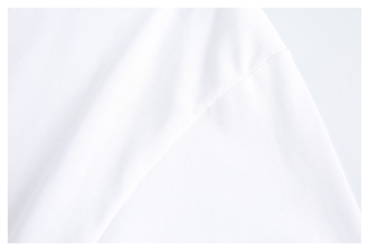 Close-up of white shirt fabric with a diagonal sleeve seam.