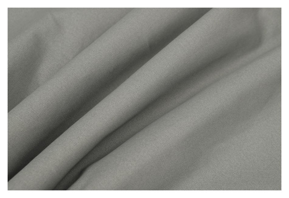 Close-up of gray fabric draped in soft folds, showing its fine surface texture.