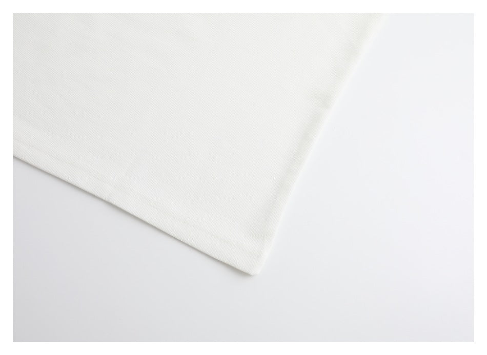 Close-up of the angled hem edge of a plain white garment.