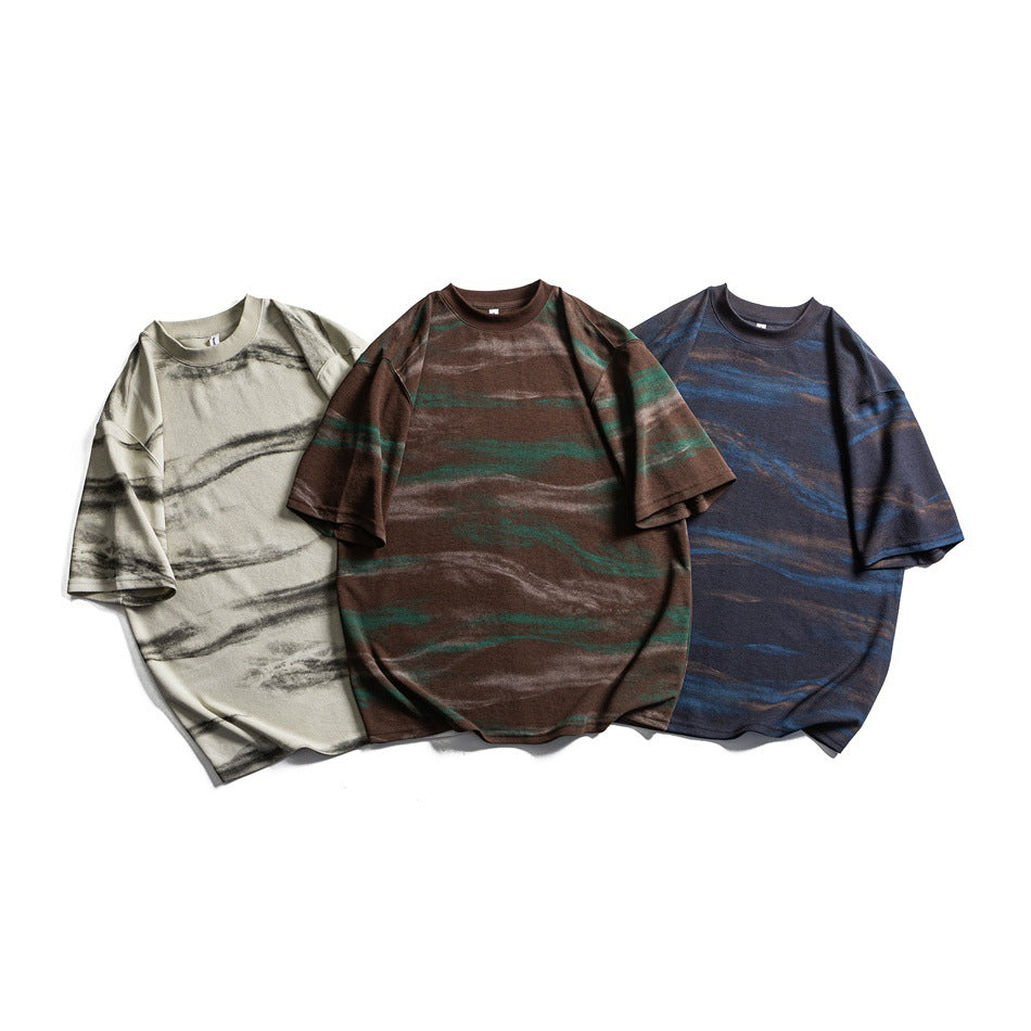 Three oversized striped T-shirts displayed together in ivory, brown with green accents, and navy with blue accents.