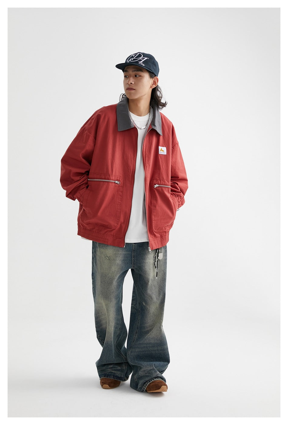 Model in a red jacket with a gray collar, center zipper, and two front pockets, shown at a slight angle.