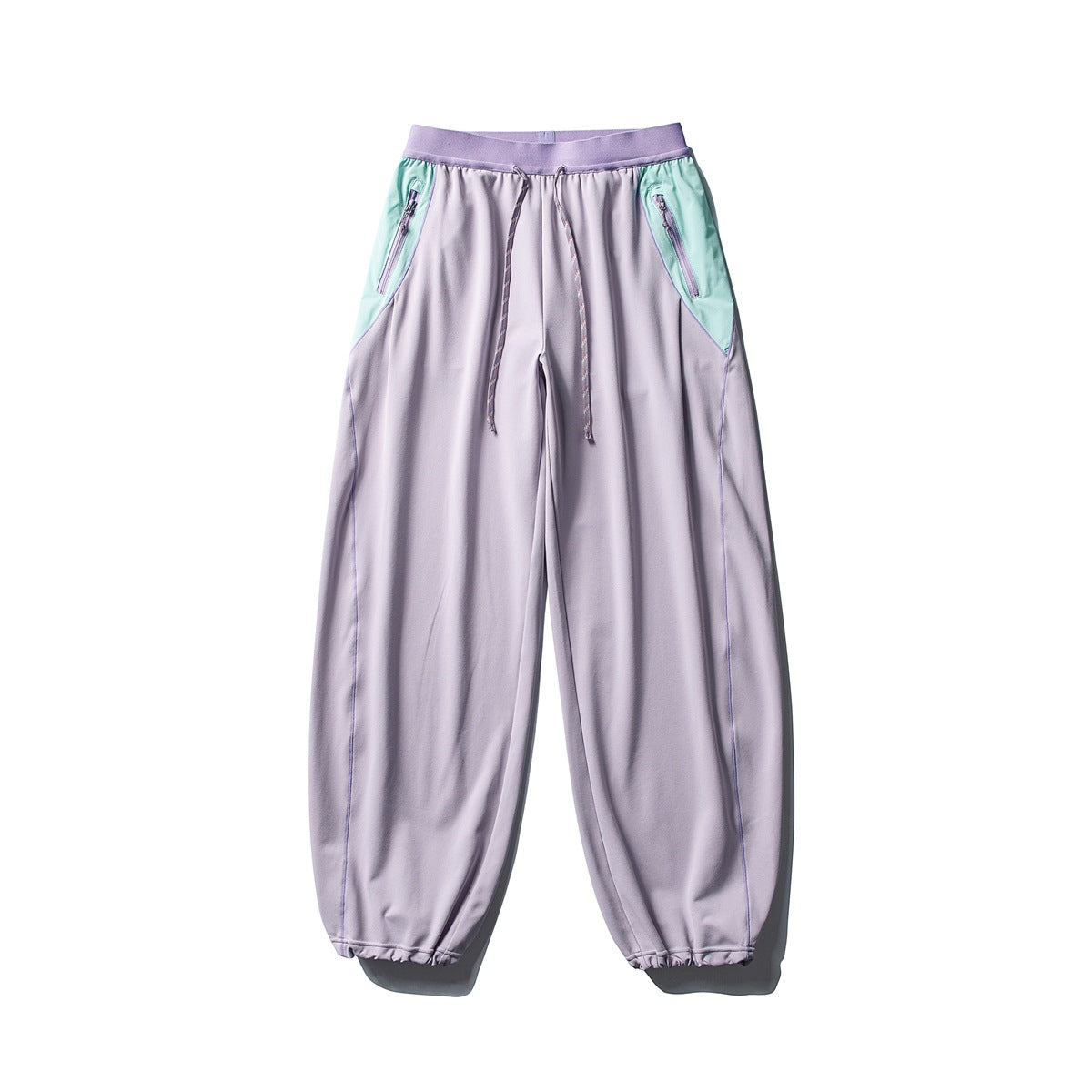 Front view of lavender wide-leg pants with mint zip-pocket panels, a lilac waistband, drawstring, and gathered cuffs.