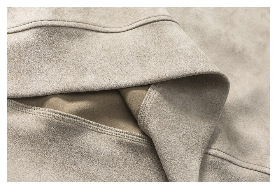 Close-up of a beige garment edge folded back to show the inner fabric and stitching.