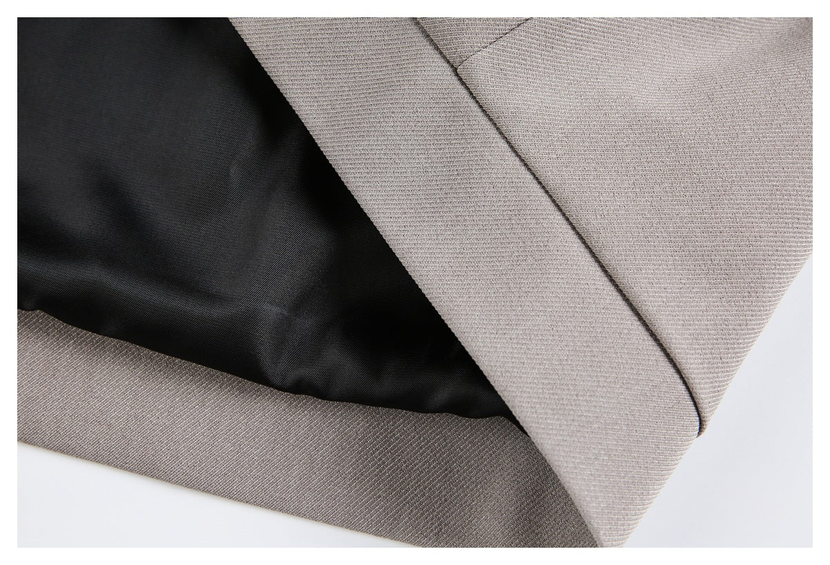 Close-up of black jacket lining inside the taupe outer fabric and hem.