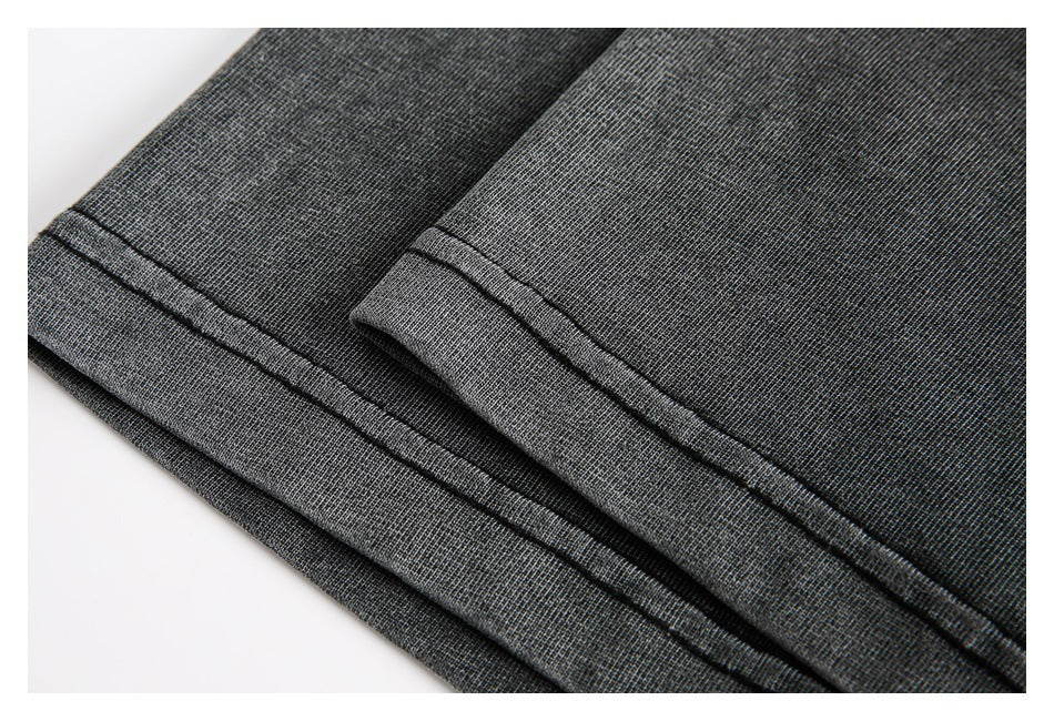 Close-up of dark gray fabric with two folded hems and visible double stitching.