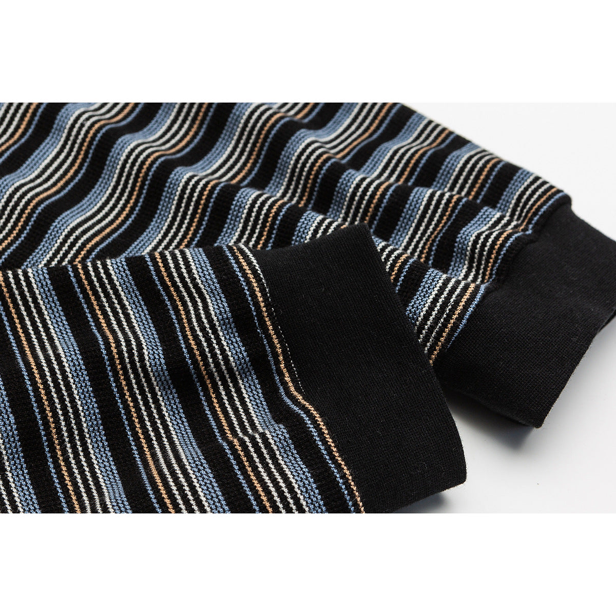 Close-up of a black striped knit top showing its patterned fabric and solid black cuff.