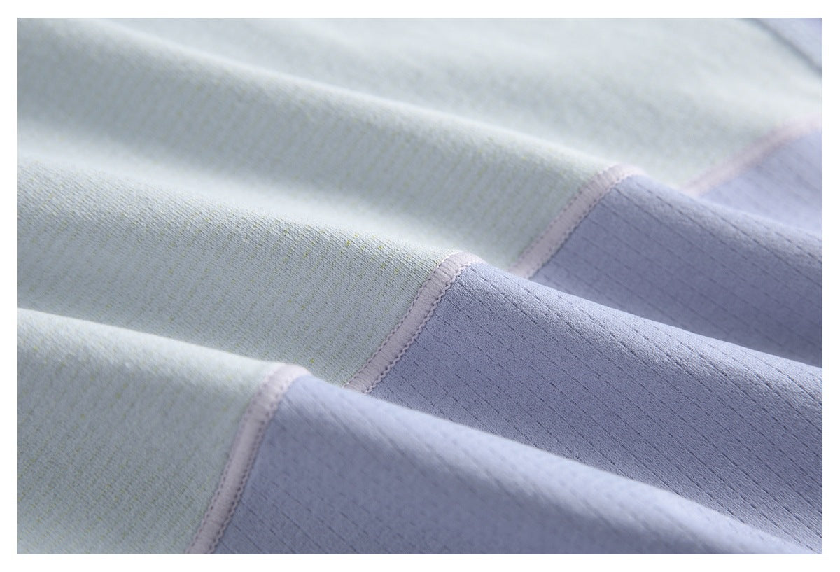 Close-up of pale lavender and light gray garment panels joined by curved stitched seams.
