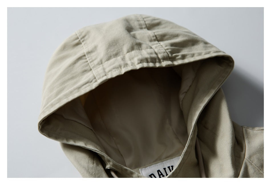 Close-up of the light khaki jacket's hood, showing its seams, lining, and a partially visible neck label.