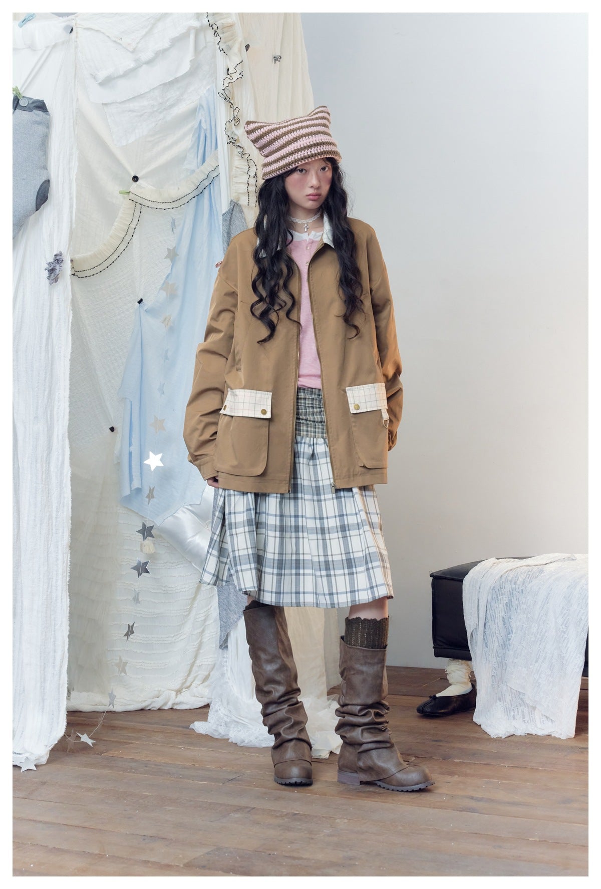 Model wearing the khaki jacket open over a pink top and plaid skirt, showing checked flap pockets