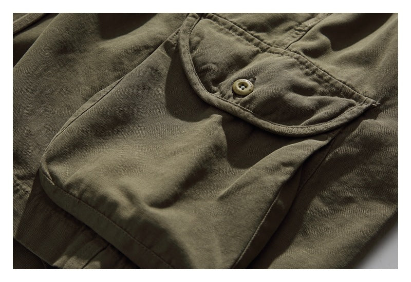 Close-up of an olive cargo pocket with a rounded buttoned flap.