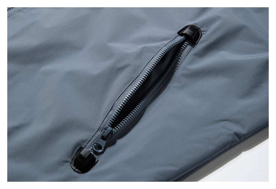 Close-up of an open black zipper on smooth gray-blue garment fabric.