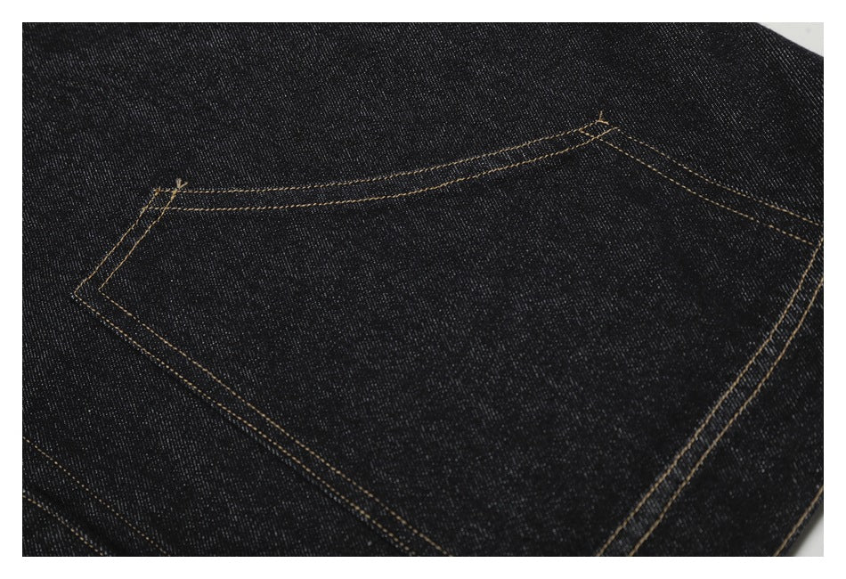 Close-up of a large patch pocket with tan double stitching on dark indigo denim.
