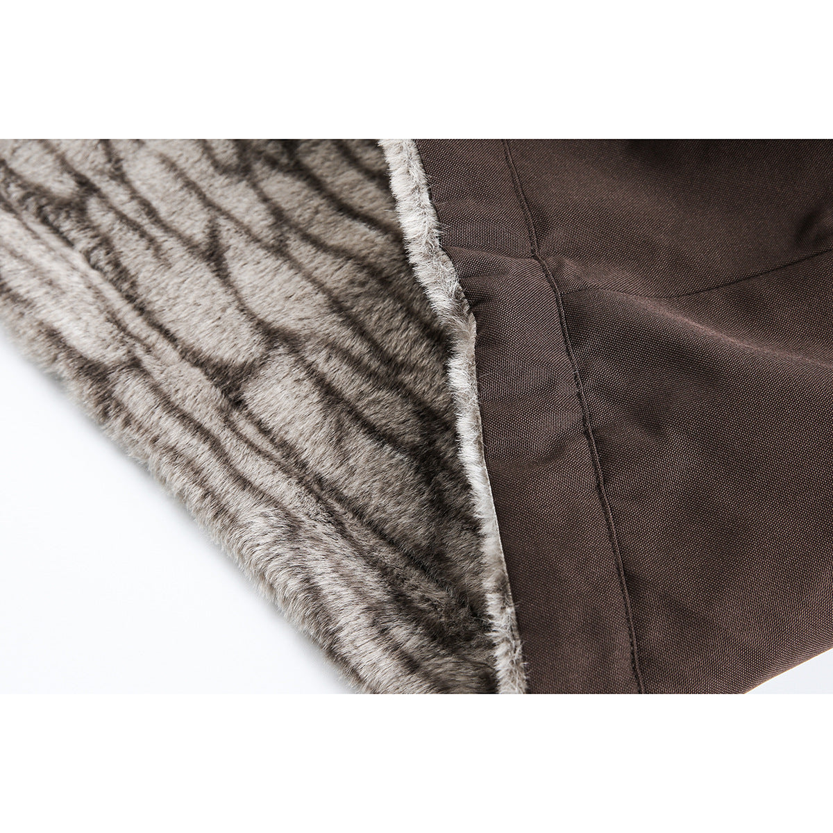 Close-up of a brown jacket's dark woven outer fabric beside gray patterned plush lining.
