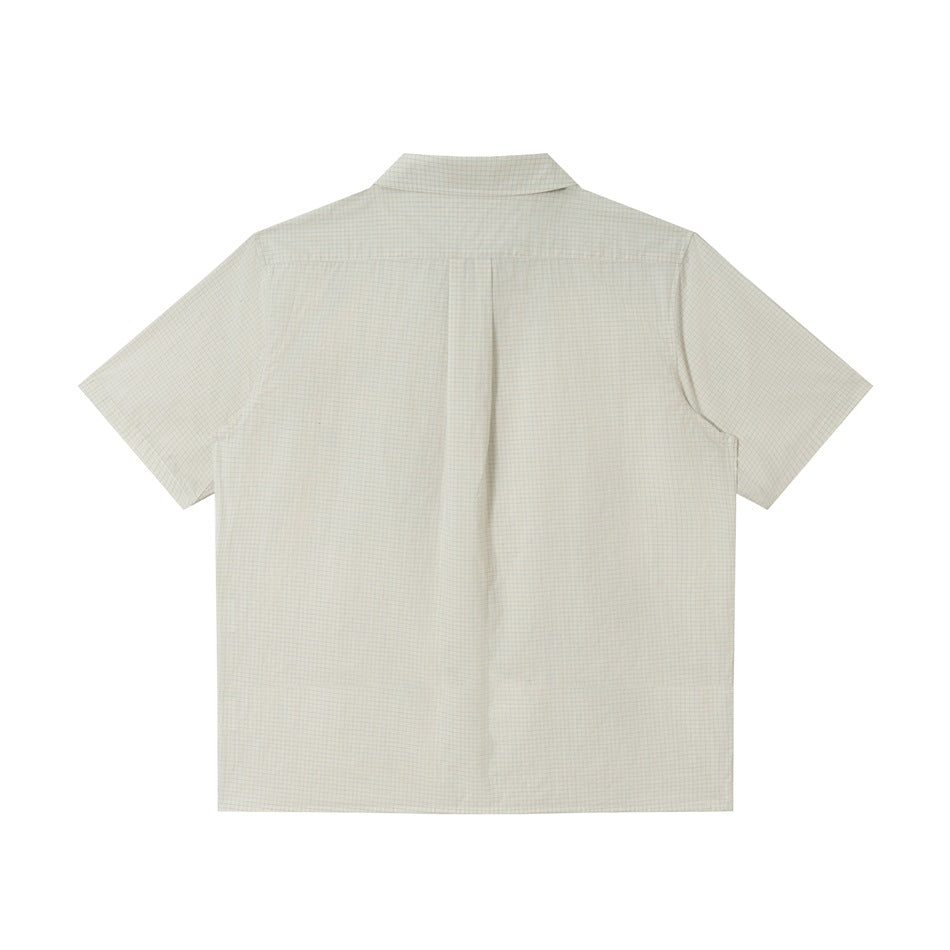 Back view of off-white fine grid check short-sleeve shirt with collar and center back pleat, flat lay