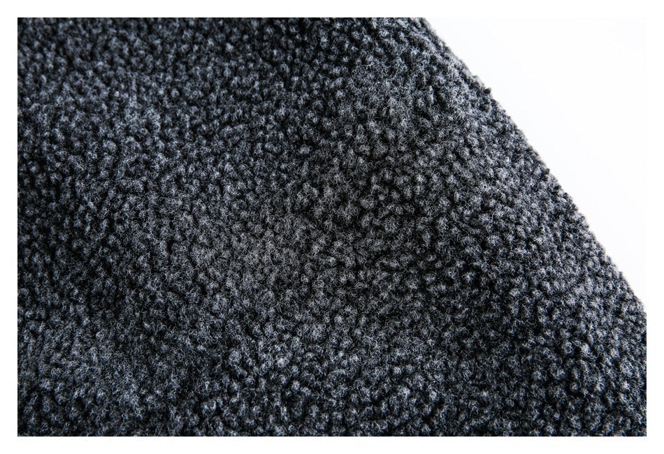 Close-up of dark charcoal bouclé fabric with a dense, looped texture.
