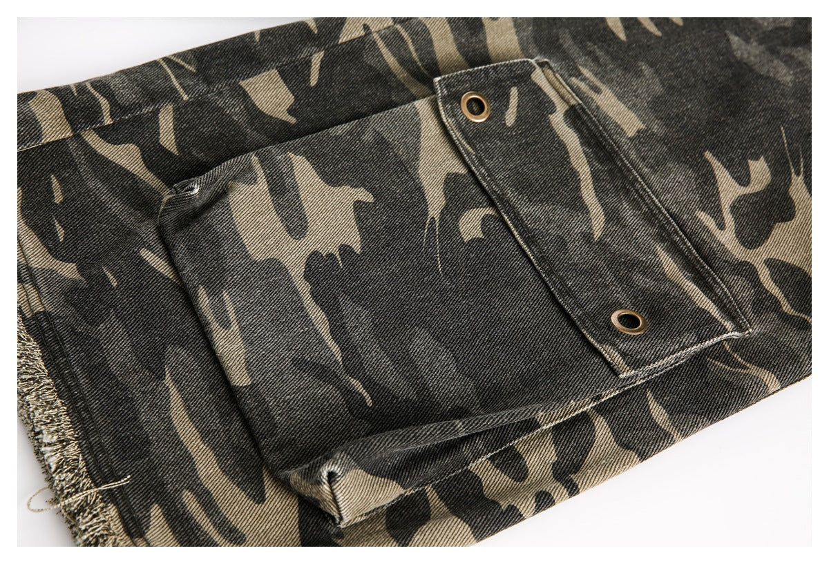 Close-up of a camouflage trouser pocket with a flap secured by two metal eyelets.