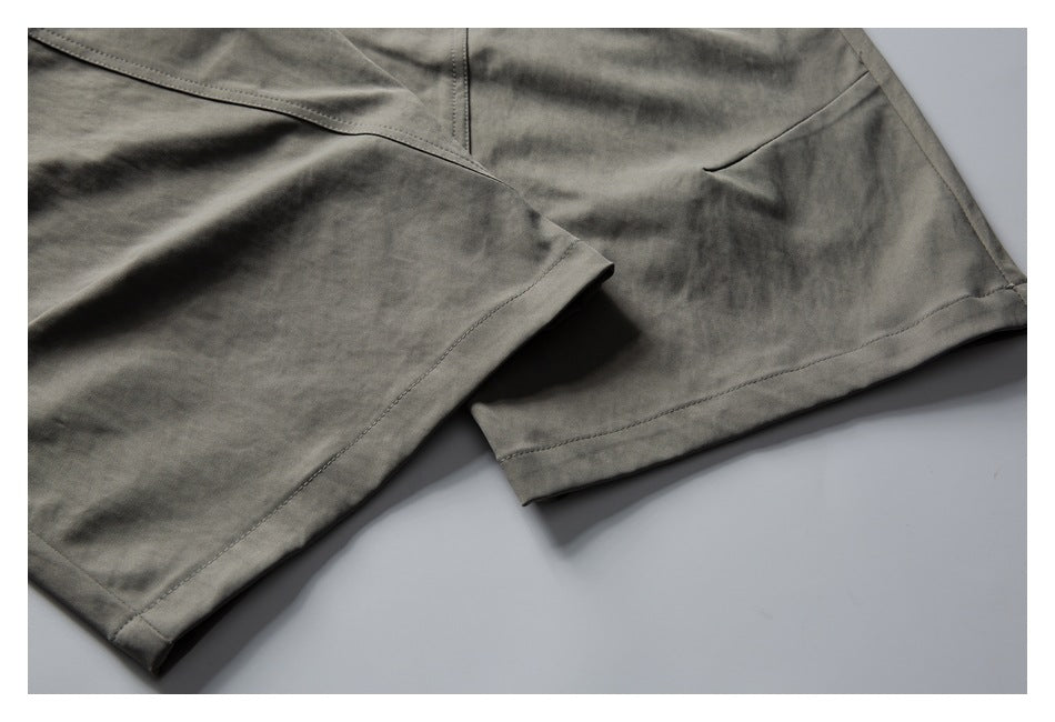 Close-up of gray shorts showing the stitched leg hems and side seam.