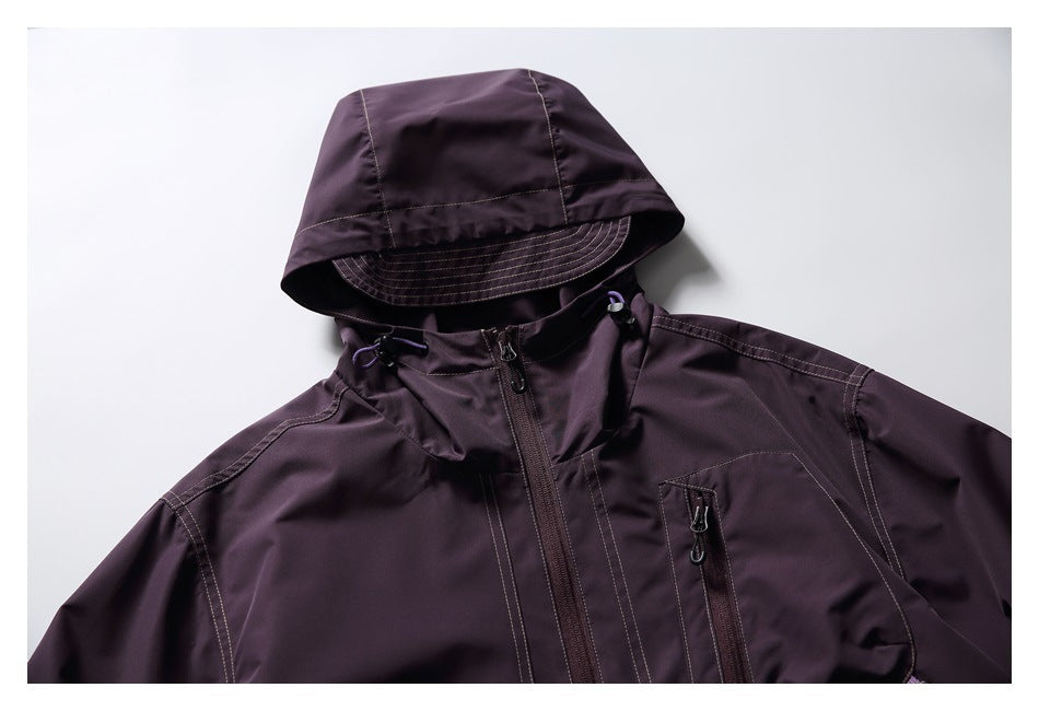 Front view of a dark plum hooded jacket with a brimmed hood, full-length zipper and zippered chest pocket.