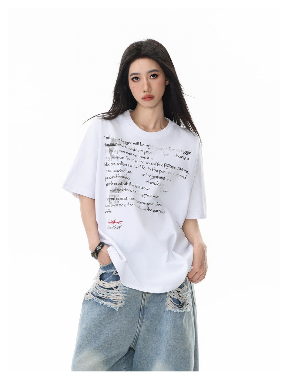 Closer front view of a model in an oversized white T-shirt with layered black text and distressed light-wash jeans.