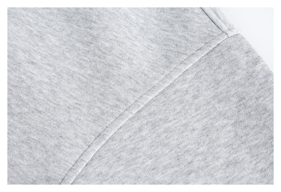 Close-up of a stitched seam joining panels of the light gray sweatshirt.