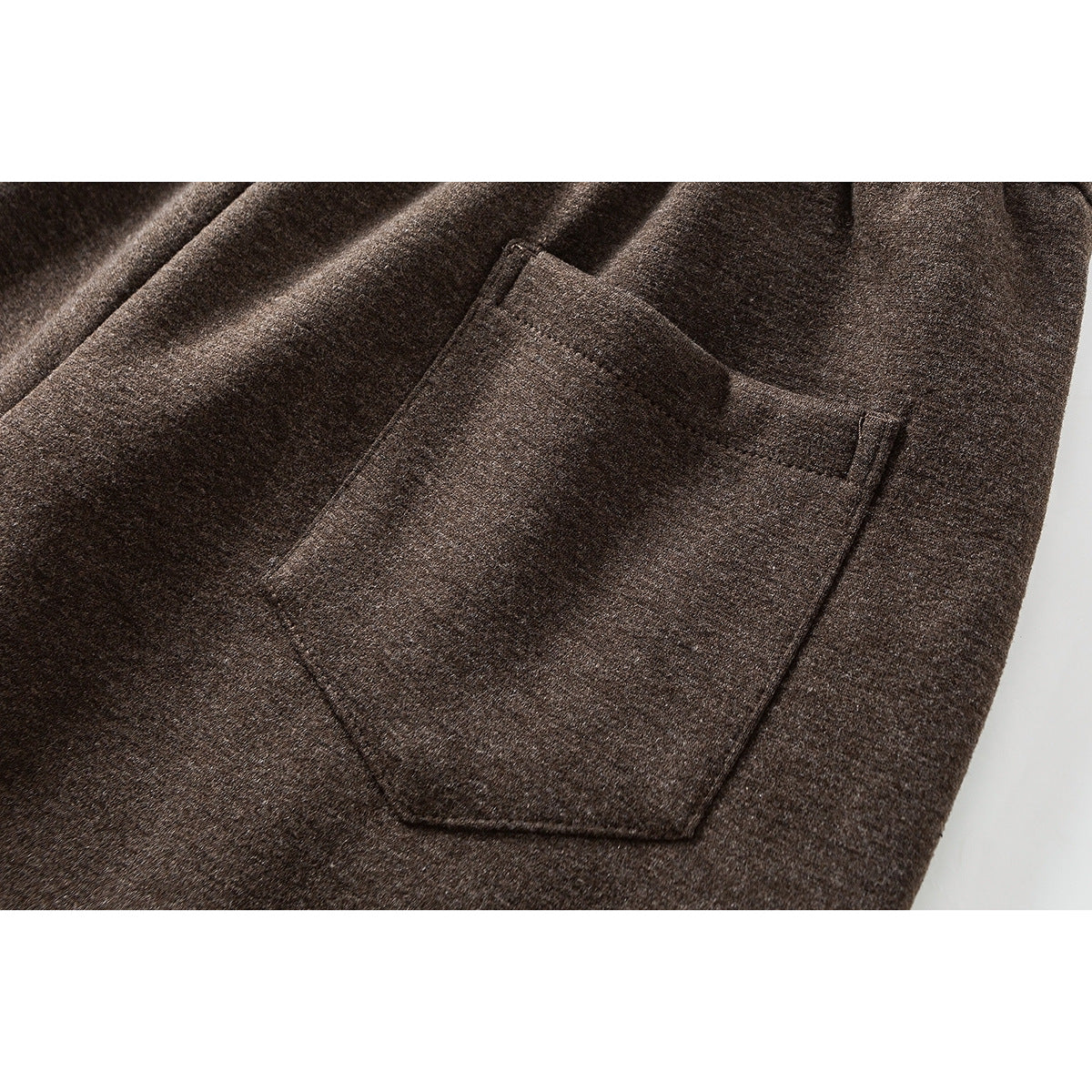 Close-up of a large patch pocket on brown wide-leg pants.