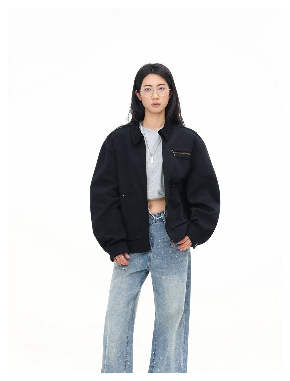 Model wearing an oversized black zip jacket with chest zip pocket and front pockets, three-quarter front view