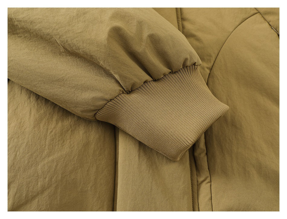 Close-up of a tan jacket sleeve with a wide ribbed cuff and gathered fabric.