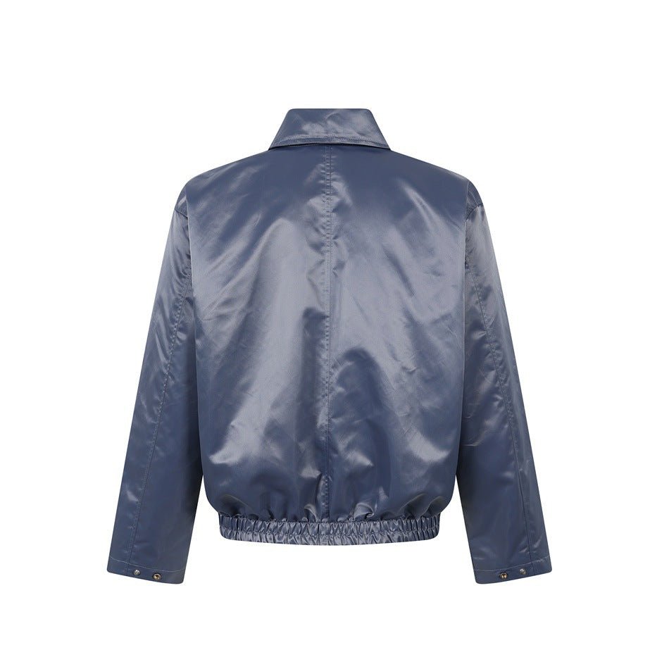 Back view of a slate blue jacket with a center seam, pointed collar, long sleeves and elasticized hem.