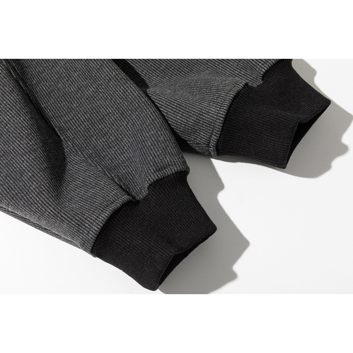 Close-up of charcoal gray sweatshirt sleeves with black ribbed cuffs.