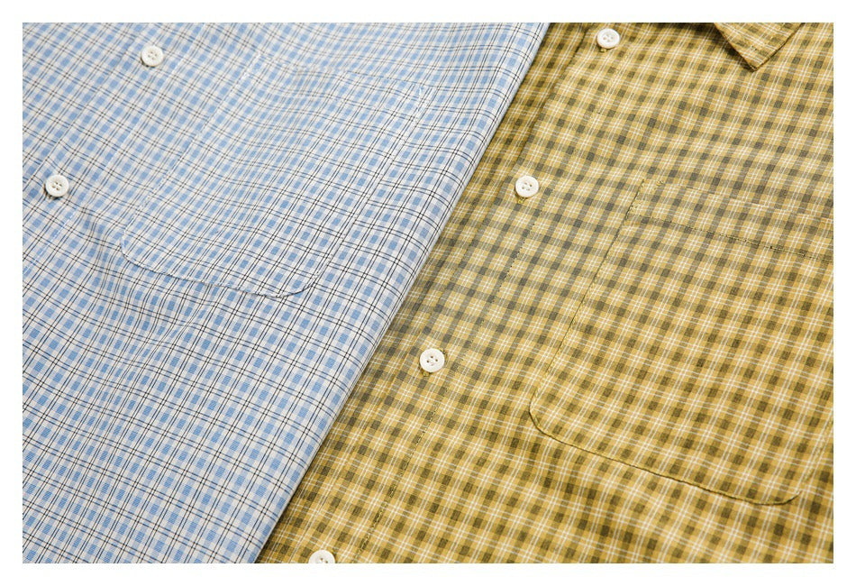 Close-up of blue and mustard-yellow plaid shirt fronts, with white buttons and chest pockets visible.