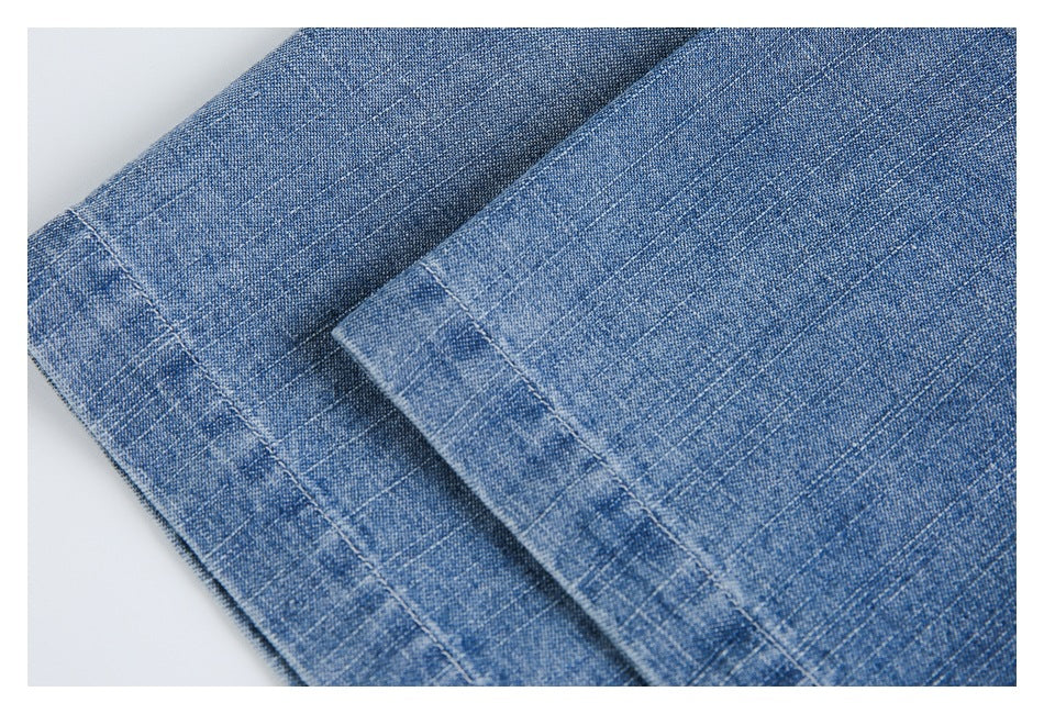 Close-up of overlapping stitched edges on blue denim fabric.