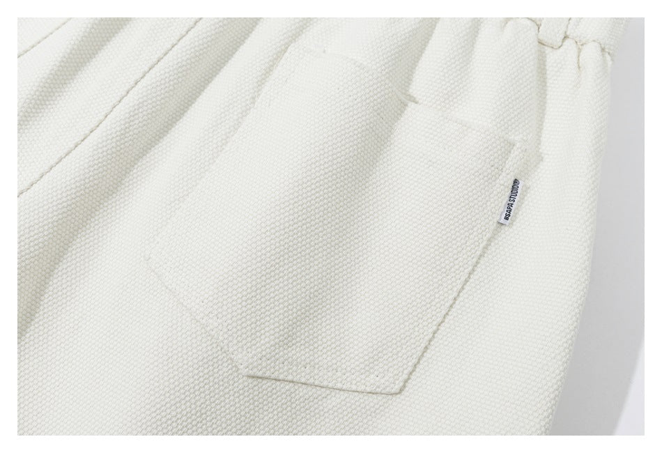 Close-up of an ivory garment pocket with a small sewn label.