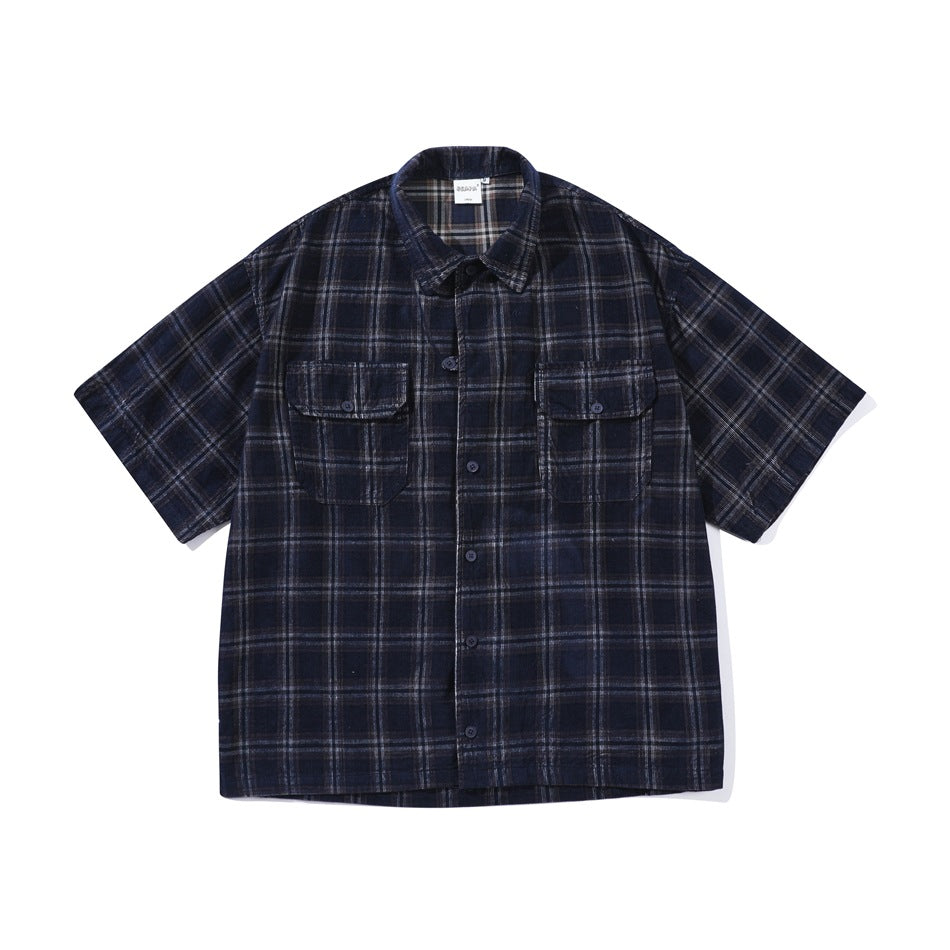 Front flat lay of a navy blue plaid short-sleeve button-up shirt with two chest flap pockets and a collar