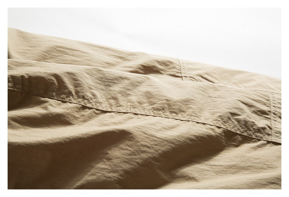 Close-up of a long stitched seam across the tan jacket fabric.