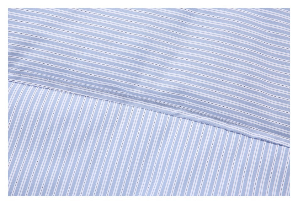 Close-up of light blue and white striped fabric with a stitched seam and stripes changing direction.