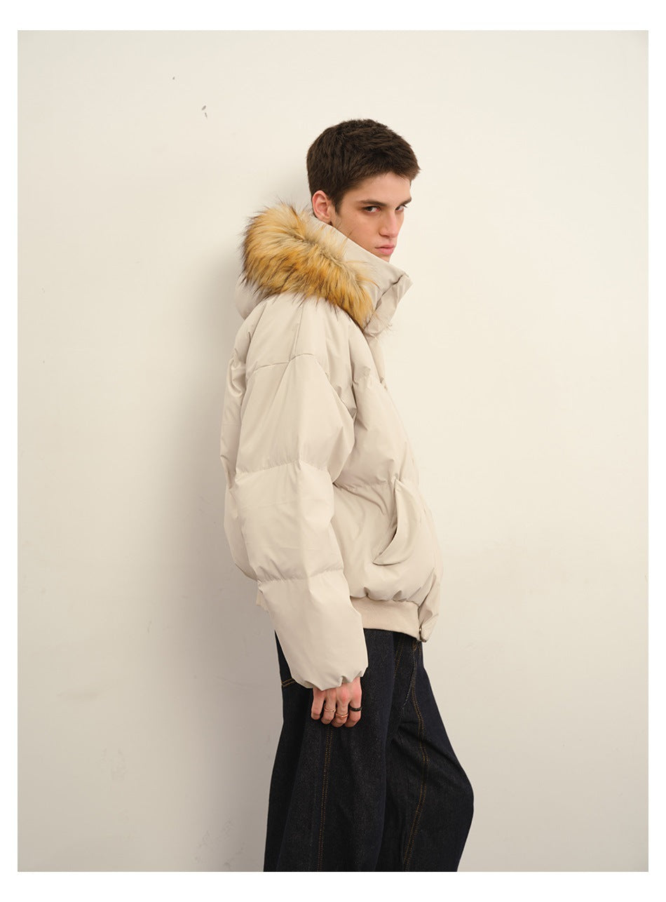Side view of a man wearing a beige puffer jacket with fur-trimmed hood and dark jeans