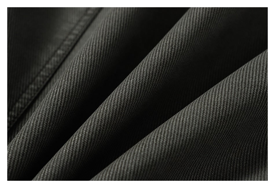 Macro close-up of the charcoal gray jacket's textured fabric and folds.
