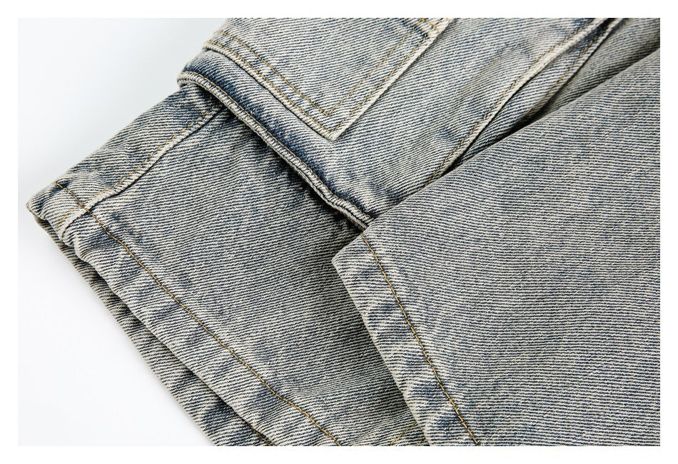 Close-up of a folded denim hem and double-stitched seam on light-wash fabric.