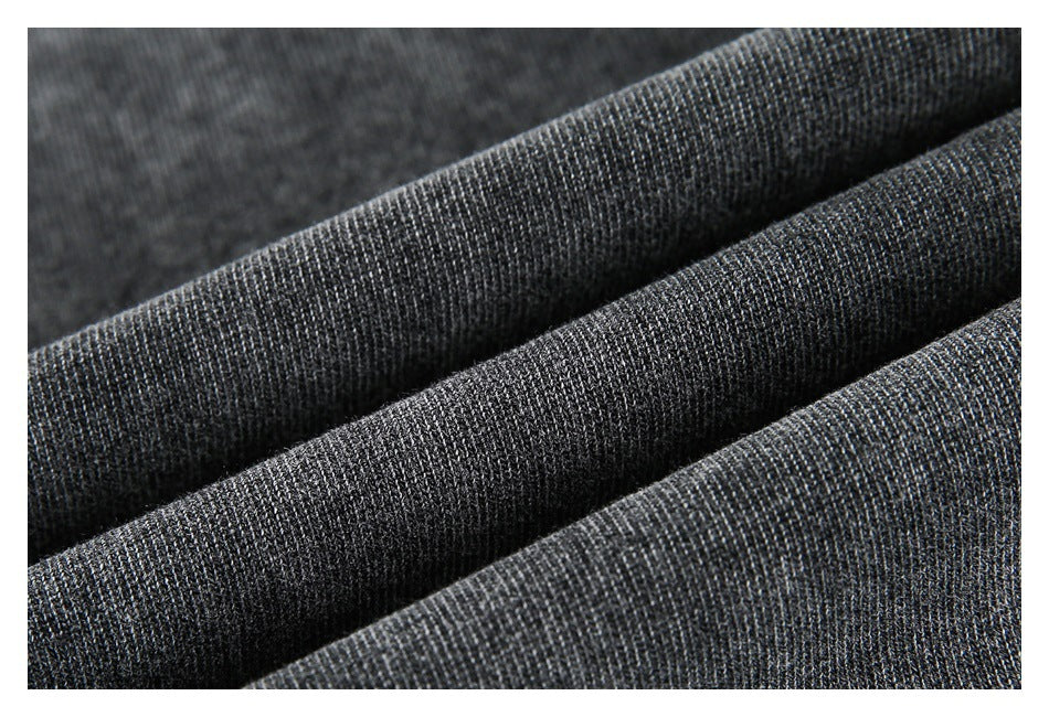Close-up of dark charcoal gray fabric arranged in soft folds, showing a fine textured knit surface.