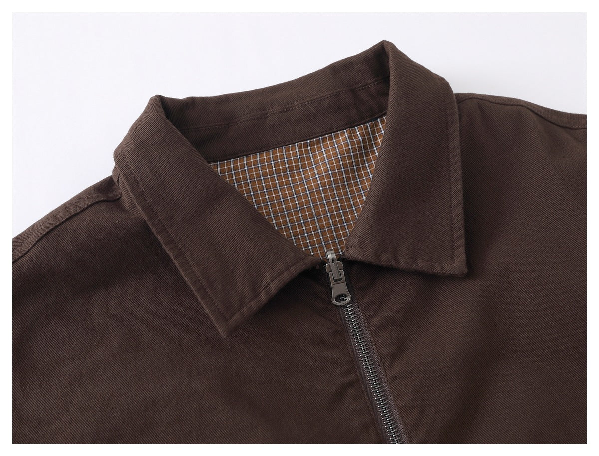 Close-up of a dark brown jacket collar, zipper, and brown-and-white checked lining.