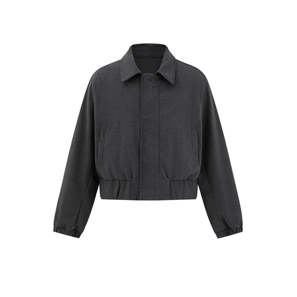 Dark gray cropped jacket with pointed collar, concealed front placket, slanted pockets and elastic hem, flat front view