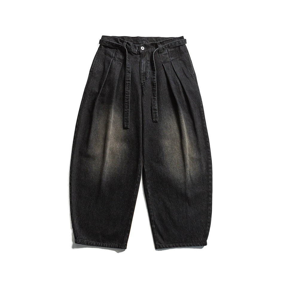 Black faded wide-leg pleated jeans with a tie belt, flat lay front view