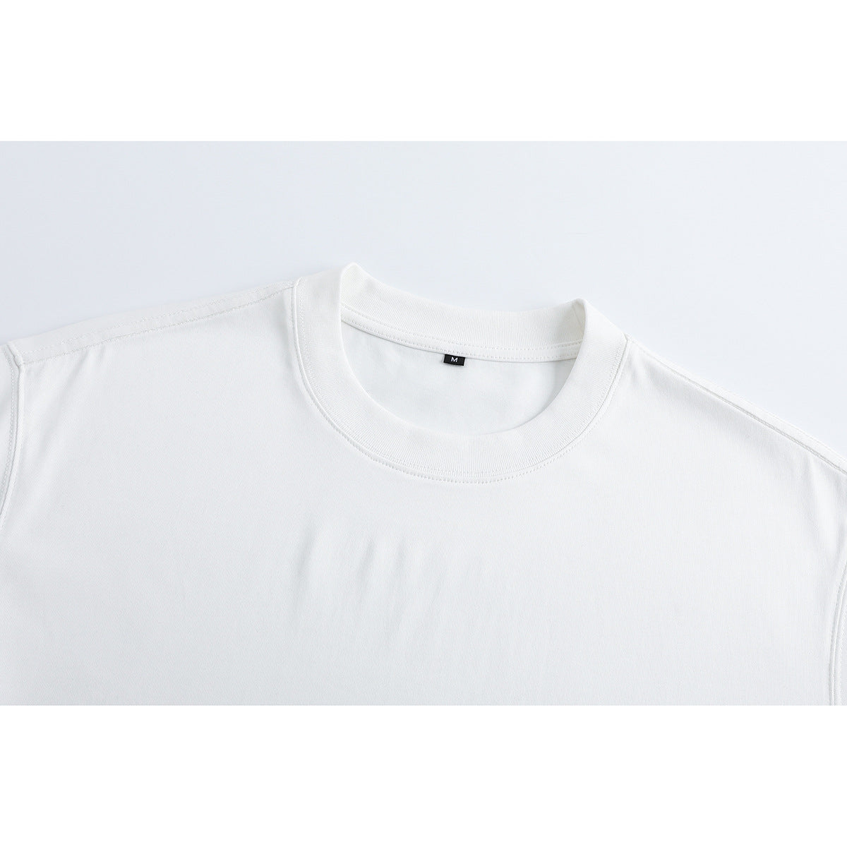 Close-up of a plain white crew-neck T-shirt collar and upper chest.