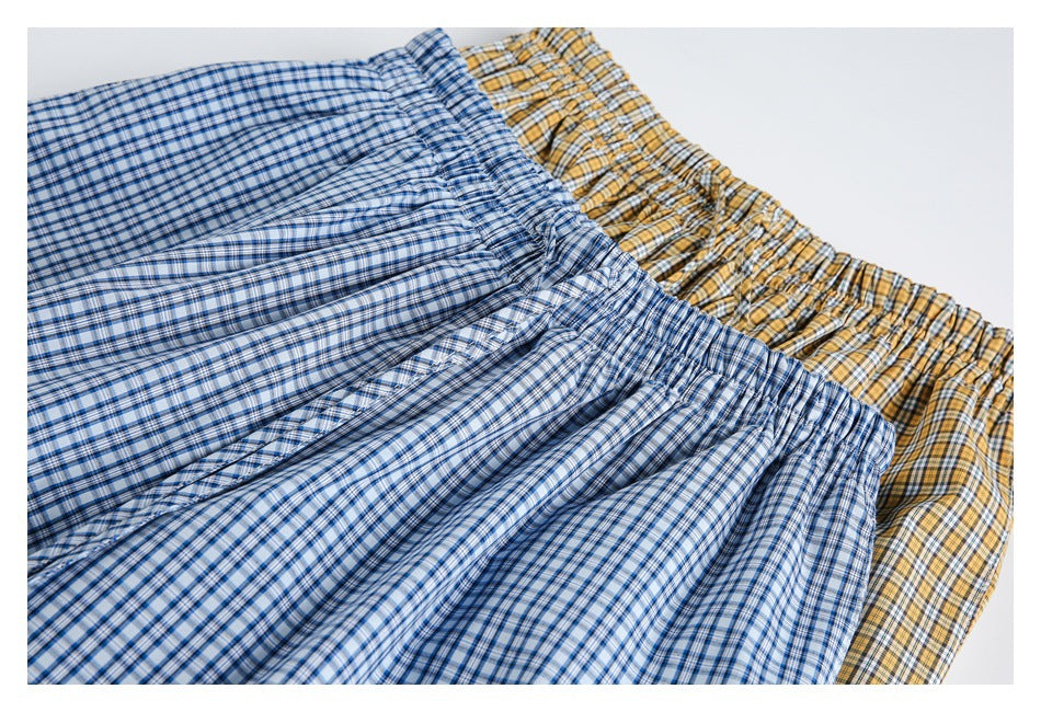 Close-up of blue-and-white and yellow checked pants, showing their gathered elastic waistbands.